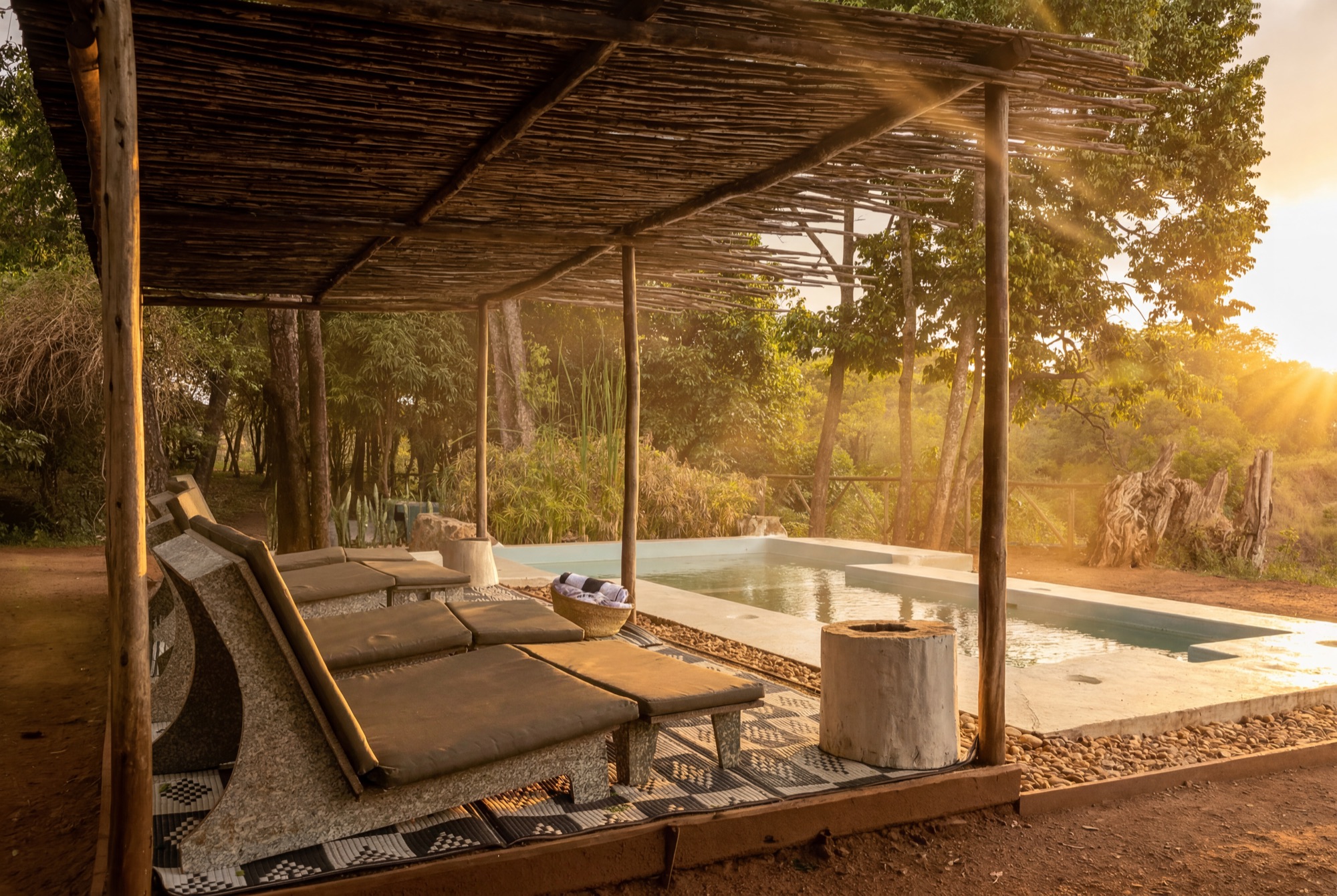 Golden-hour lounging deck beside a lodge pool